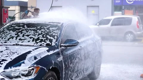 A guy washes a car at a car wash Stock Footage 337171909