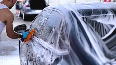 A guy washes a car at a car wash Stock Footage 337171916