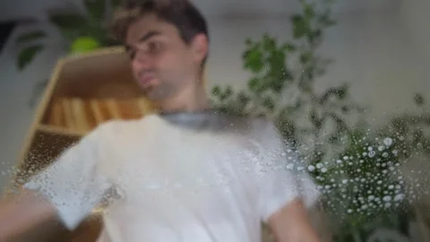 The guy washes the glass table, the man washes the glass Stock Footage 264887134