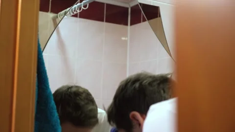 The guy washes in the morning in the bathroom in front of the mirror Stock Footage 264887954