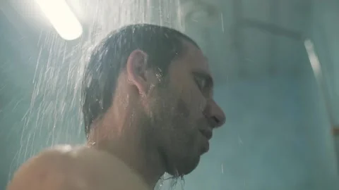 Guy washes in the shower after training from the tap water flows2 Stock Footage 138317042
