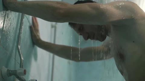Guy washes in the shower after training from the tap water flows3 Stockbeeldmateriaal 138634290
