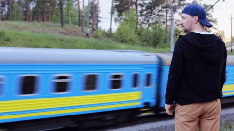 The guy watches as the train passes in the forest 스톡 동영상 90450968