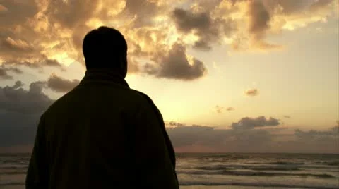 Guy watching sunset at the beach Video stock 20510376