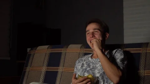 The guy is watching TV laughs, the fun guy is watching TV Stock Footage 126093439