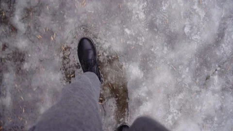 Guy in waterproof boots walking through thawed stream. Stock Footage 168333834