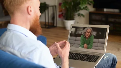 A guy waving hand, greeting with a senior woman on the laptop screen Stock Footage 200834090