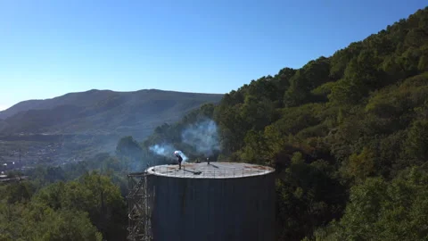 Guy is waving a signal light while standing on a water-pressure tower Stock-Footage 143069862