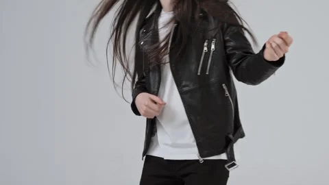 Guy wearing a black rocker jacket imitates playing an airy invisible guitar Stock Footage 287915229