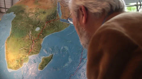 Guy wearing brown jacket watching Africa map in globe closer Stock Footage 36150255