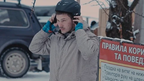 Guy wears a helmet for snowboarding Vidéo 72277209