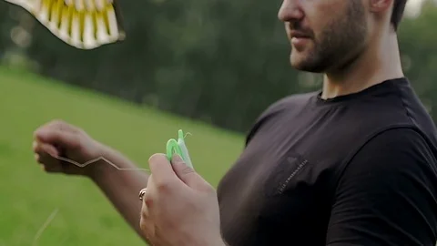 Guy is winding a kite Stock Footage 79610054