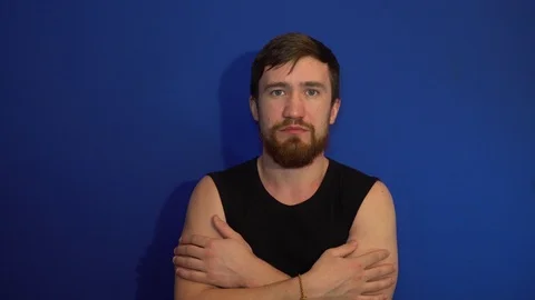 The guy winks, standing on blue background 库存影片 124464855