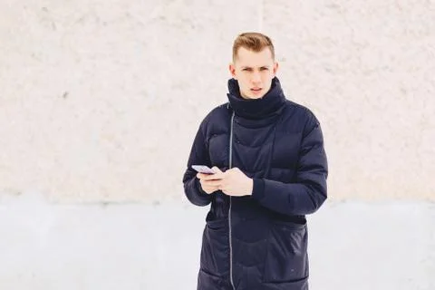 Guy in winter jacket writes sms Stock Photos