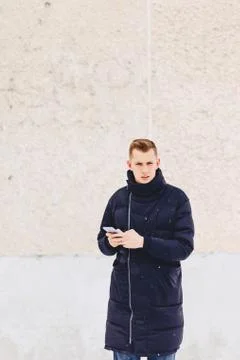 Guy in winter jacket writes sms Foto stock