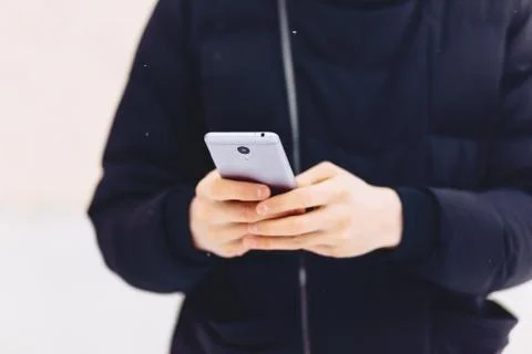 Guy in winter jacket writes sms Stock Photos