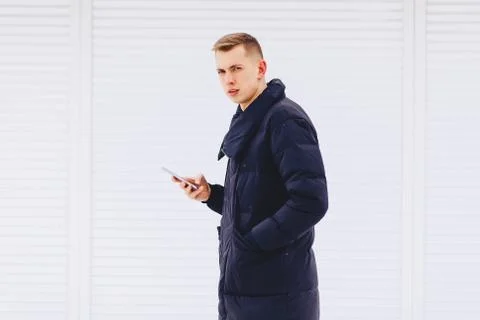 Guy in winter jacket writes sms Stock Photos