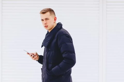 Guy in winter jacket writes sms Stock Photos