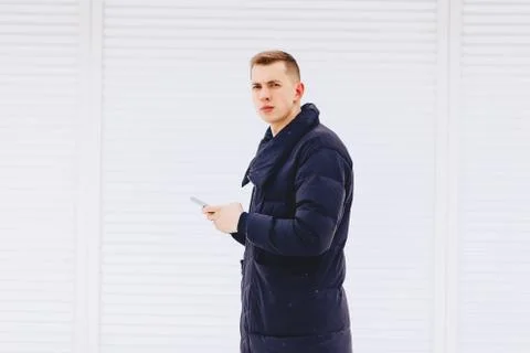Guy in winter jacket writes sms Stock Photos