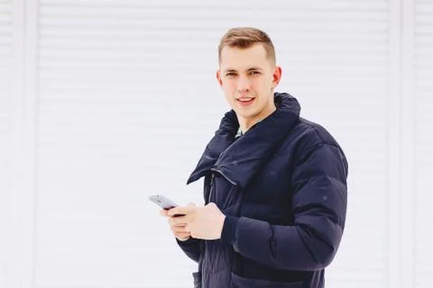 Guy in winter jacket writes sms Stock Photos