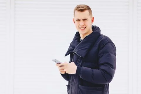 Guy in winter jacket writes sms Stock Photos