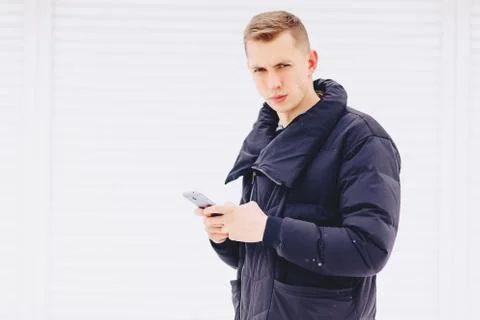 Guy in winter jacket writes sms Foto stock