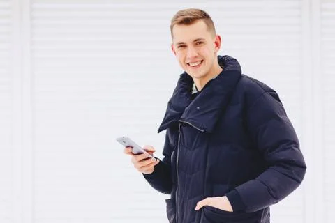 Guy in winter jacket writes sms Stock Photos