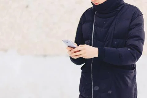 Guy in winter jacket writes sms Stock Photos