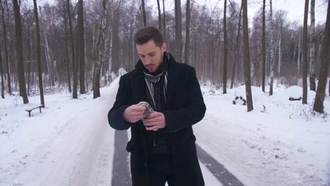 The Guy is on a Winter Road. and Finds Gloves in his Pocket  Video stock 163466788