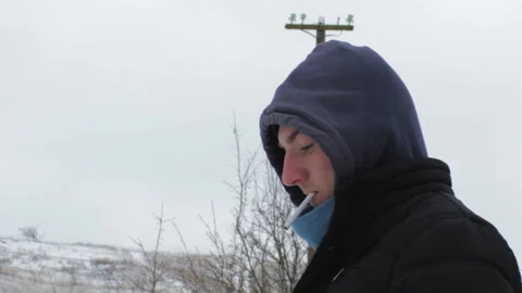 Guy in the winter smokes a cigarette Stock Footage 119156452