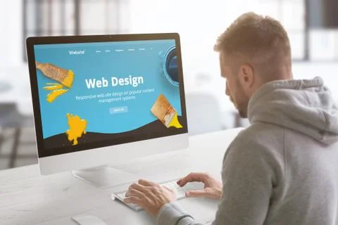Guy work on modern web site on computer in graphic, web design studio office. Stock Photos