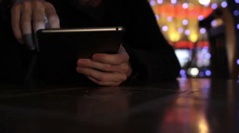 A guy working on a tablet with one hand in cafe bokeh background Video stock 47763186