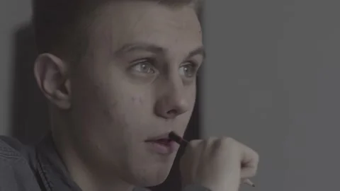 The guy writes, draws. The guy is sitting at the table by the laptop Stock Footage 130219843