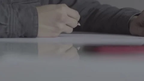 The guy writes, draws. The guy is sitting at the table by the laptop Stock Footage 130219974