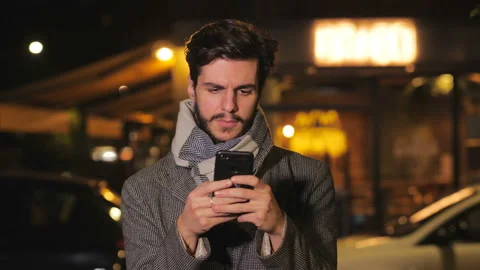 Guy writes messages and checks his smartphone Stock Footage 152706691