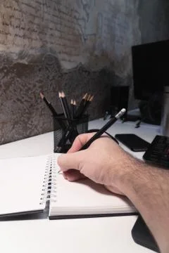 The guy writes with a pencil in a notebook Foto stock