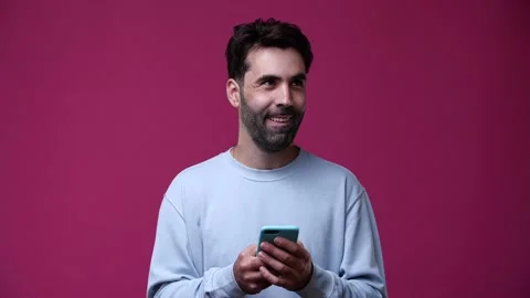The guy writes SMS on the phone, thinks what to do but then smiles Stock Footage 162842944