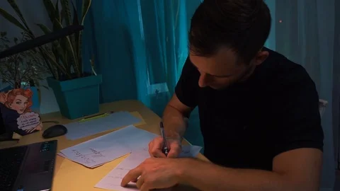 The guy at the yellow table, writes a letter to the girl, in the room, flat Stock Footage 121360555