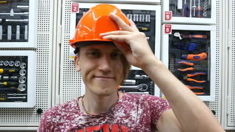 Guy is young and exciting Builder in orange helmet. Stock Footage 122386623