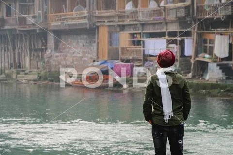 Guy young man alone with a travel backpack in Fenghuang Ancient town background. Stock Photos