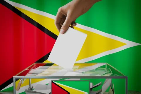 Guyana flag, hand dropping ballot card into a box - voting concept Stock-Illustration