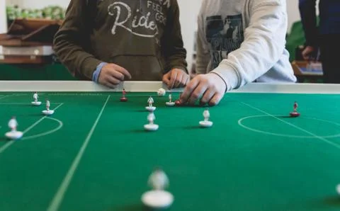 Guys are playing subbuteo. Group of table top games simulating team sports. Stock Photos