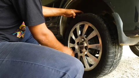 A guys changing a car tyre with the proper equipment Stock Footage 101721703