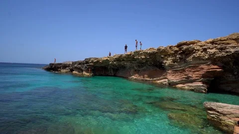 Guys diving from the rocks into the sea. Stock Footage 95802513
