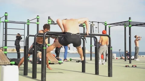 Guys do a workout near the beach in slow motion Stock Footage 101269976