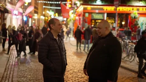 Guys drinking a beer in the Temple Bar district of Dublin by night - travel Video stock 229443865