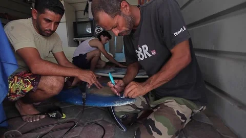 The guys fixing the surfboard Stock Footage 148627624