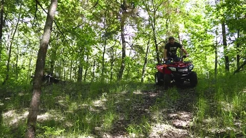 Guys, men on an ATV ride down a small hill. Quad bikes in the forest. Stock Footage 139884493