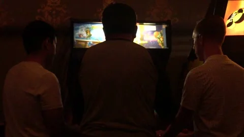 Guys Playing Arcade Game Stock Footage