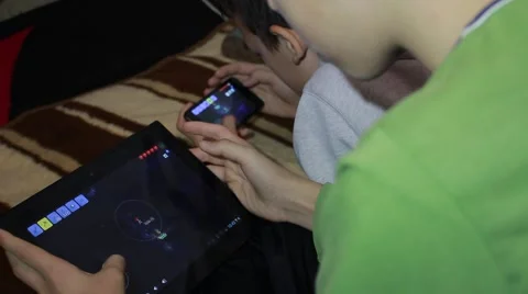Guys playing a computer game on the tablet and smartphone together Vídeo Stock 58126691